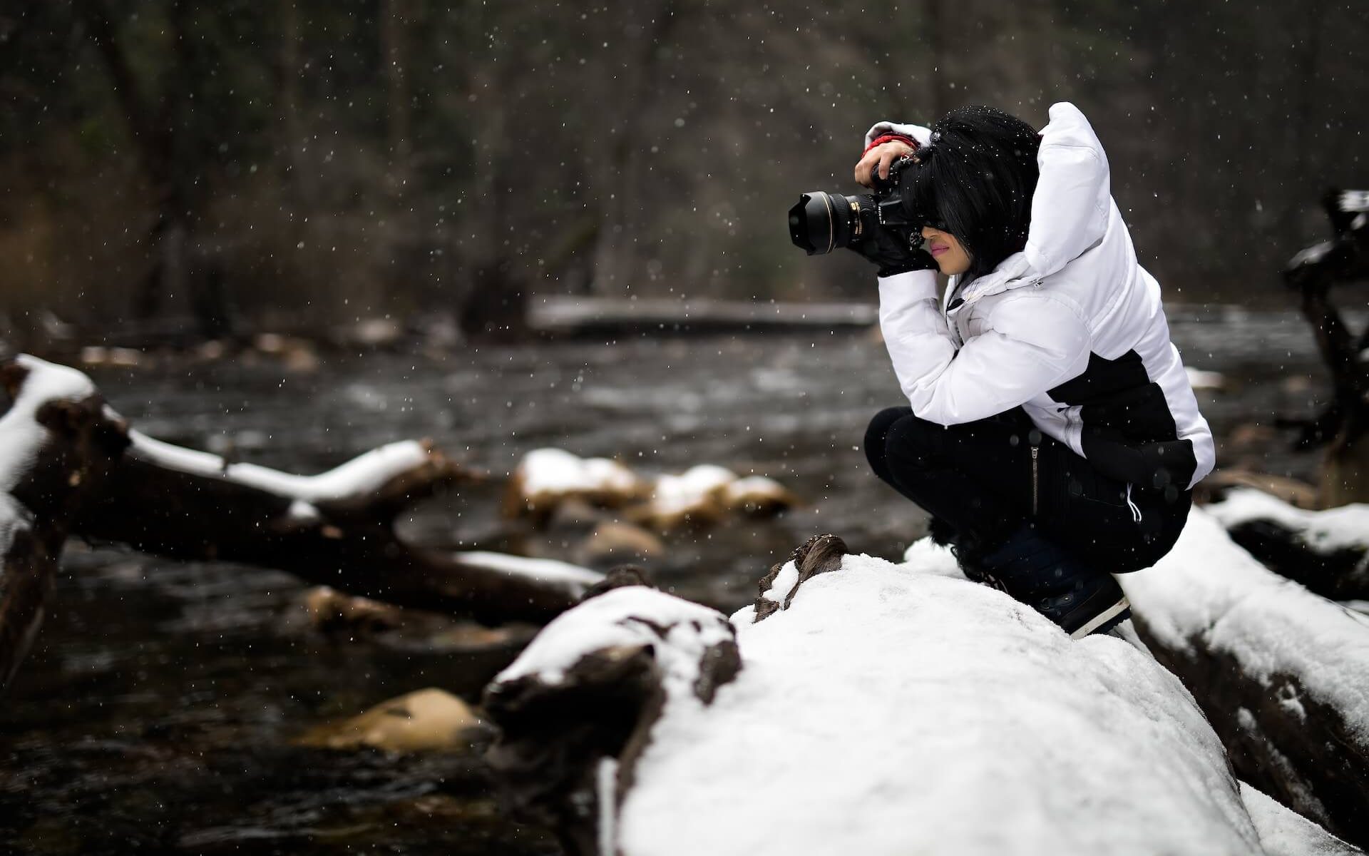 Woman capturing photos in a snowy setting.