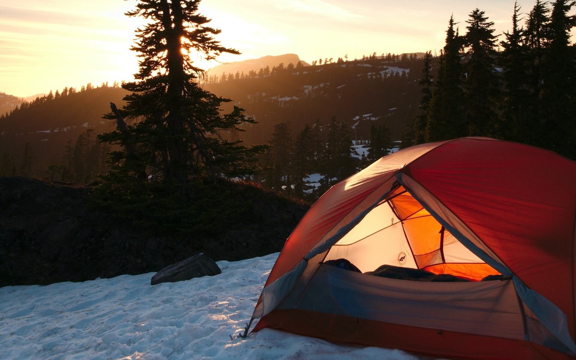Tent set up in a snowy mountain landscape.